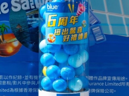 圓柱扭蛋機貼上藍色品牌周年活動貼膜,機內裝滿深淺不一的藍色扭蛋